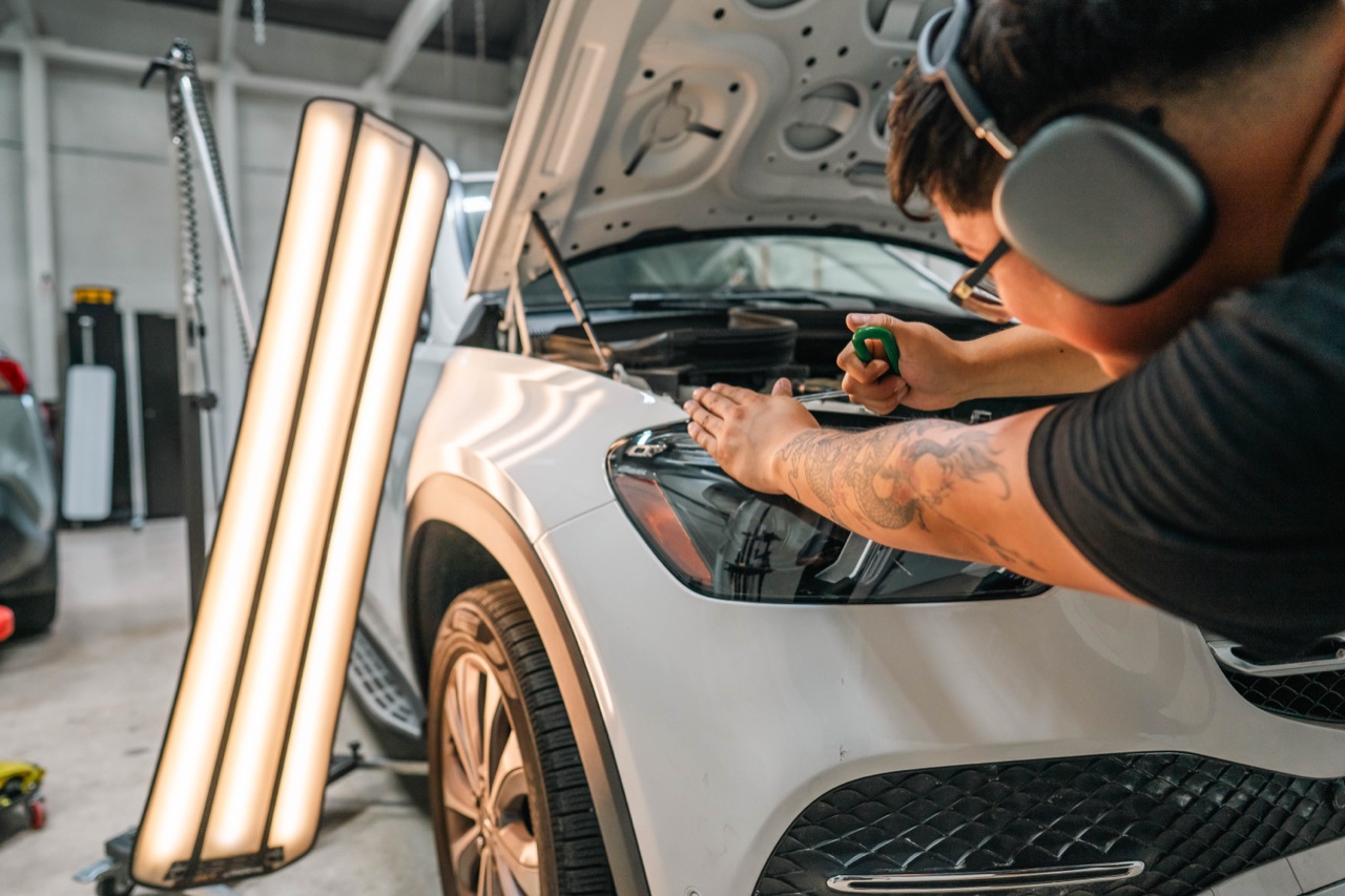 Pro PDR technician reading body-line dent under precision PDR light bar